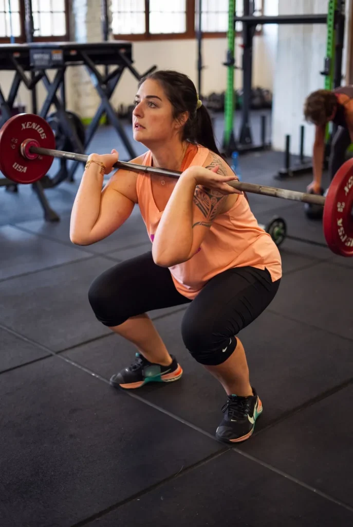 Adhérente en plein effort sur un front squat chez Farmer CrossFit à Plaisir (78)