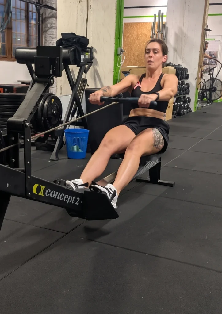 Adhérente au rameur pendant un entraînement HYROX chez Farmer CrossFit à Plaisir